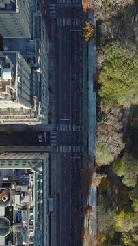 Vertical video: Aerial birds eye overhead top down view of buildings and street along Central park. Two towers of historical San Remo building. Manhattan, New York City, USA