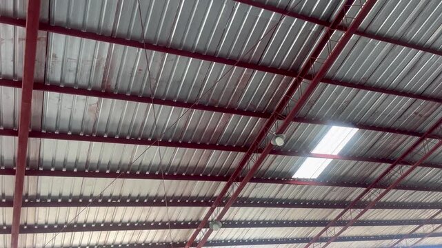 Corrugated metal roof structure with steel frame inside a warehouse