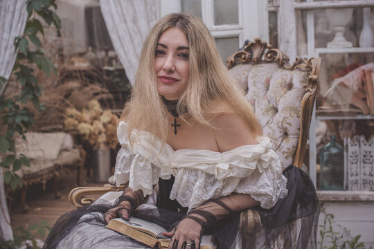 Woman in a vintage Victorian dress reading an old book, getting absorbed into a romantic gothic novel