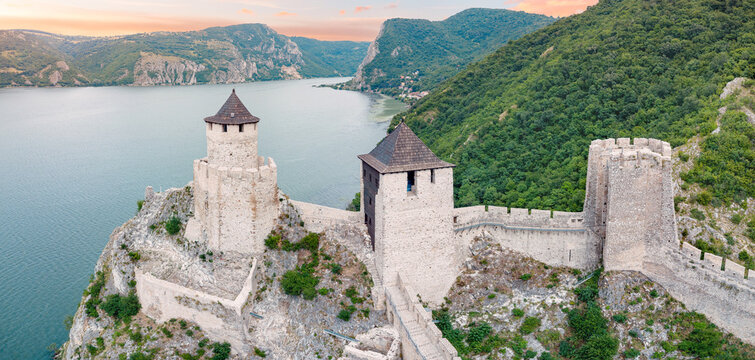 Wide-angle aerial panoramic frame places stone towers of Golubac fortress with the Danube gorge receding behind
