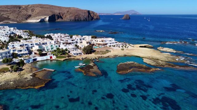 aerial view of rocky beach on Greek island of Milos in the Cyclades, drone shot of turquoise Mediterranean Sea and whitewashed houses in Pollonia fishing village, Greece
