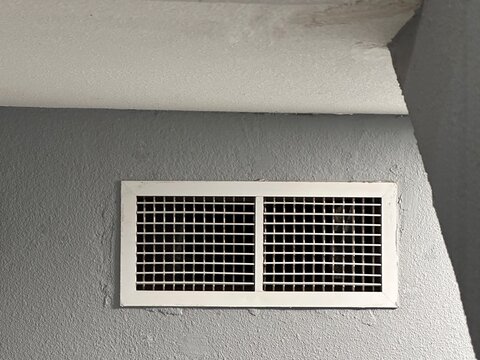Modern rectangular wall vent on gray interior ceiling with copy space