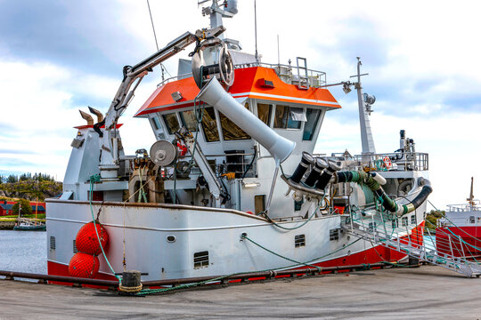 Modern commercial fishing vessel with deck equipment moored in harbor