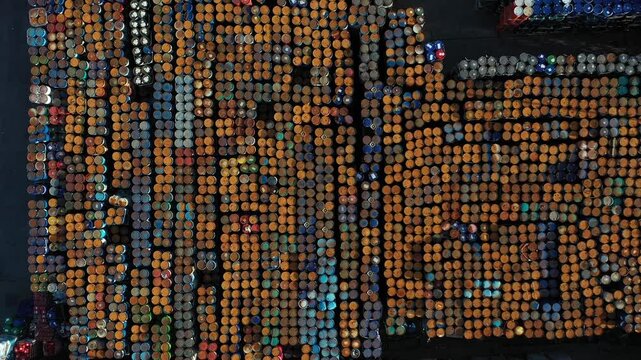 Aerial view of numerous industrial barrels arranged in rows in an industrial yard in Roeselare, Flanders, Belgium.