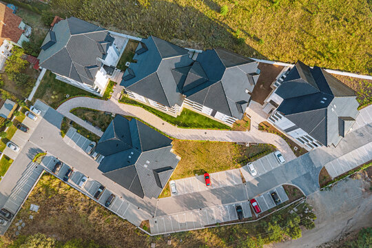 Drone view of a new suburban housing estate with winding roads and parking - ideal for real estate marketing and property development