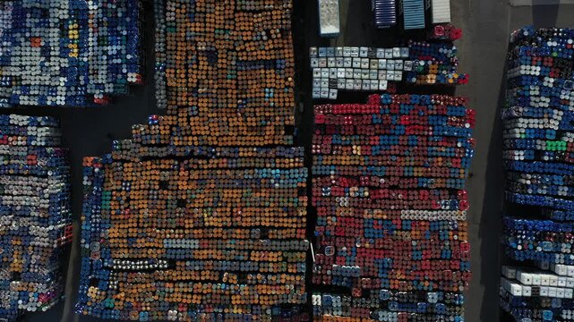 Aerial view of colorful industrial barrels and containers neatly arranged in rows at a storage facility in Roeselare, Flanders, Belgium.