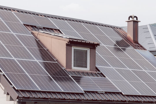 Solar panels covering a house roof, generating renewable energy for sustainable living and reducing carbon footprint