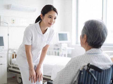 車椅子に乗った患者に優しく寄り添い話しかける看護師