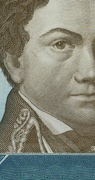 Macro Sequence of Venezuelan Banknotes. Macro views of Venezuelan banknotes progress across several designs, highlighting printed portraits, colorful details, and currency denominations.
