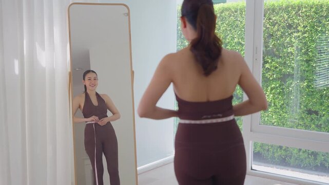 Rear view people young adult asian woman self measure waist size shape lean body mass index fat by tape track weight loss perimenopause life anti aging diet preventive modern medicine asia health care