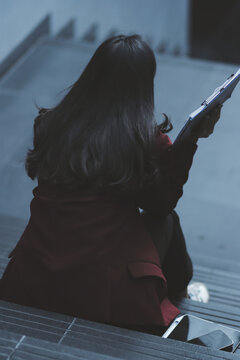 desperate Asian Korean business woman crying alone sitting on street staircase suffering stress and depression crisis being victim of mobbing or fired losing her job