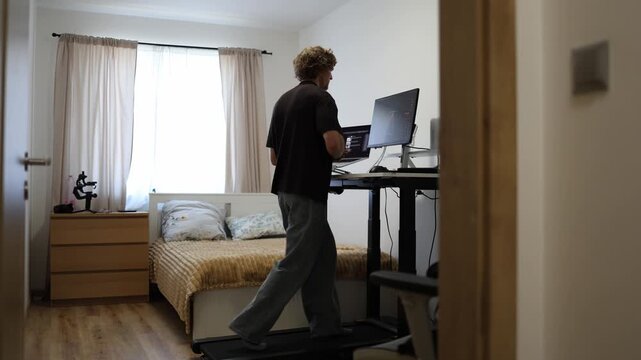 Young trader celebrates a profitable stock sale while walking with a dance step on a treadmill enjoying success after making money from a winning market trade at home now