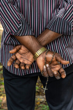 Hands holding a rosary behind the back, Togoville, Togo