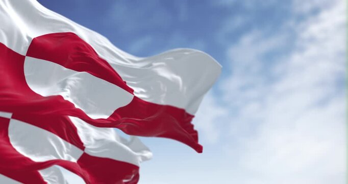 Flags of Greenland waving in the wind on a clear day.