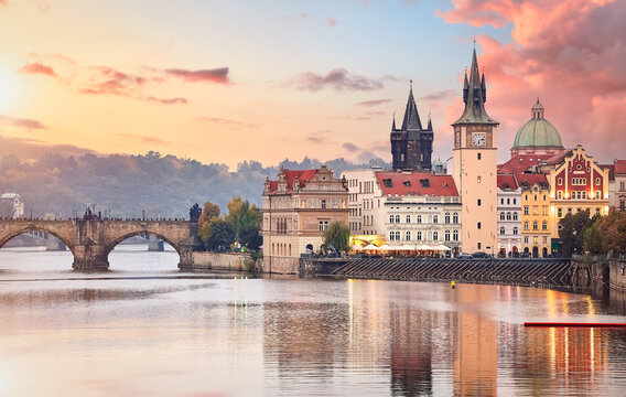 Fall landscape view to Charles bridge on Vltava river in Prague Czech republic with blue sky and sunset.