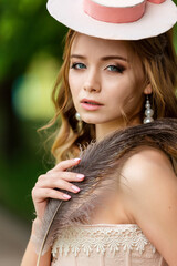 Beauty portrait of elegant young woman with feather and pearl earrings © Shkriabii