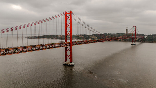 Aerial view of the 25 de Abril Bridge from the side, showing.