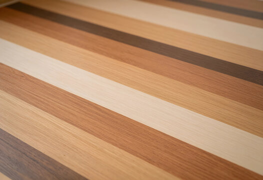 Interior design and architecture background, wooden floor texture with parallel stripes of different natural wood tones and grain patterns in perspective
