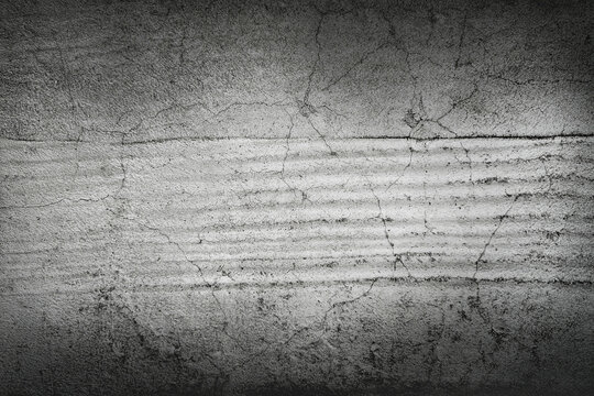 Grungy cracked concrete wall texture with horizontal lines and dark vignette