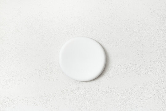 Product presentation scene made with white round podium on travertine texture background. Top view.
