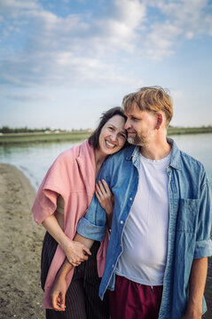 A smiling couple enjoys their summer vacation on the sandy beach