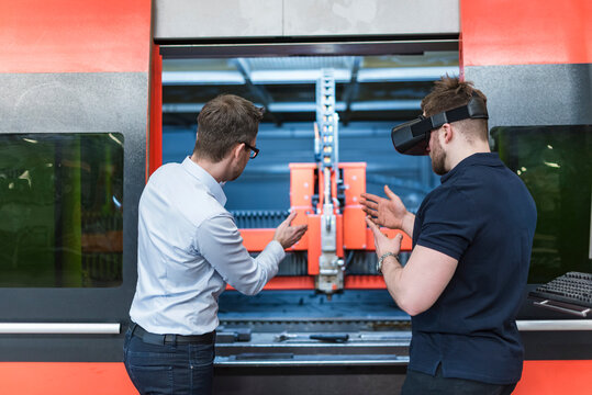 Male engineer discusses virtual reality in production facility