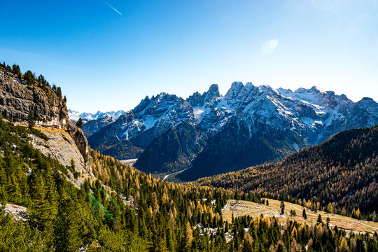 Snow capped mountains rise above an autumn valley in South Tyrol