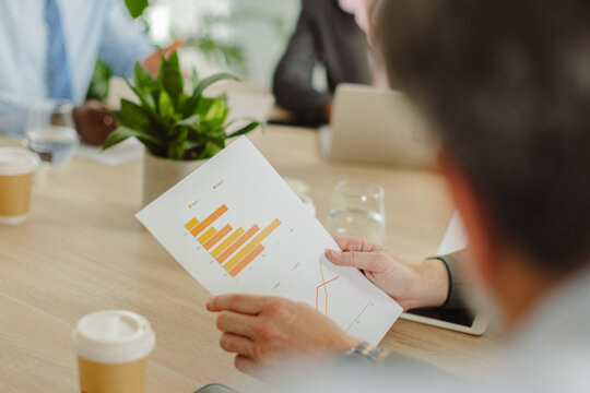 Businessman analyzes financial chart during office meeting