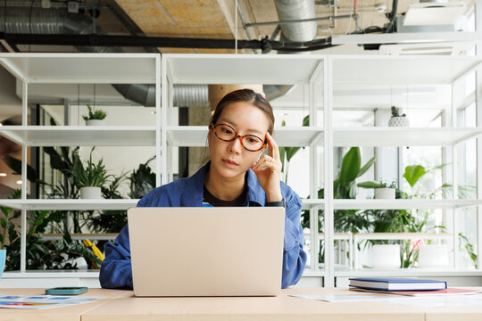 A concentrated businesswoman works on a laptop at the office