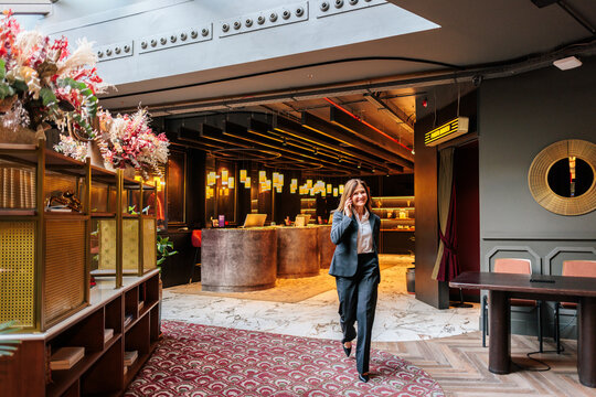 Businesswoman uses a smartphone in a modern hotel lobby