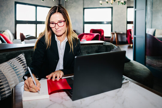Businesswoman writes in a notebook at a hotel restaurant