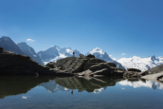 Europe, Switzerland, Grisons, South Engadin Alps, Upper Engadin, Mature woman hiking along lake fuorcla surley