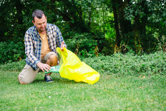 Man cleans up plastic waste in the park for recycling