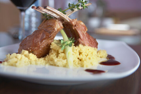 Plate of lamb loin with couscous on table