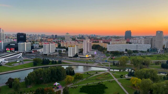 Panorama of central Minsk, featuring views of the Svislach River, the Sports Palace, and the Trinity Suburb. Aerial view of Minsk cityscape with Svislach River and modern skyscrapers under pink sunset