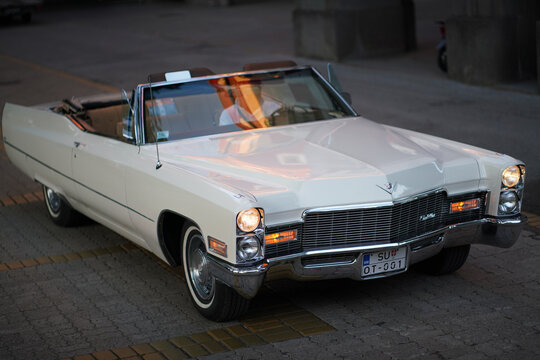 Cadillac DeVille Convertible 1968 white fullsize vintage open top car oldtimer driving high angle front three quarter view on paved road, Subotica, Serbia, Jul 4, 2026