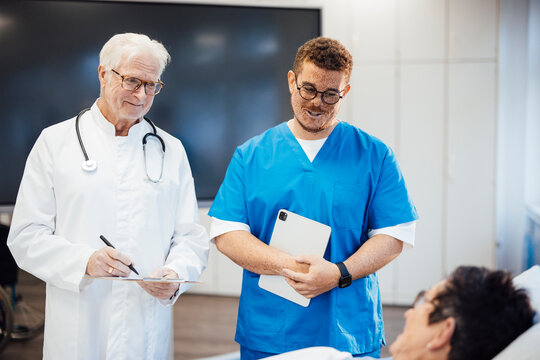 Doctor and nurse consulting patient in hospital clinic setting