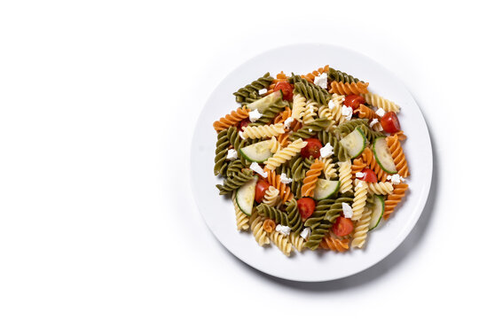 Colorful tricolor pasta salad isolated on white background. Top view. Copy space