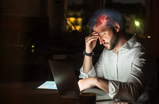 Stressed businessman suffers a headache working in the office