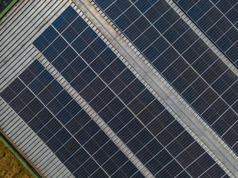 Aerial view of solar panels installed on a large industrial rooftop in Banyumas Regency, Central Java, Indonesia.