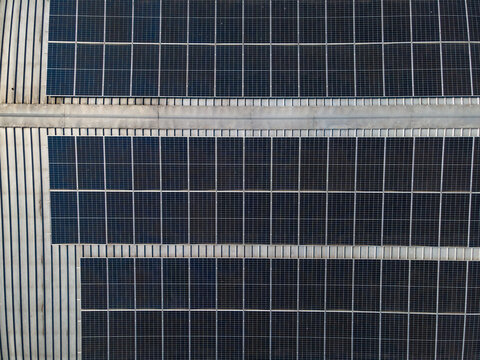 Aerial view of solar panels installed on a metal roof, showcasing renewable energy infrastructure in Banyumas Regency, Central Java, Indonesia.