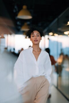 Female model portrait in modern office corridor wearing white blouse for fashion editorial and portrait background