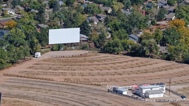 Aerial view of the Holiday Twin Drive-In theater featuring a large white movie screen, parking rows, and surrounding residential neighborhood in Fort Collins, Colorado, United States.