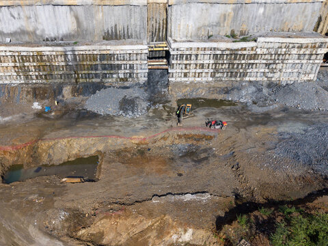 Aerial view of a construction site with heavy machinery including an excavator and a telehandler working on an excavation area with a concrete retaining wall in Istanbul, Istanbul, Turkiye.