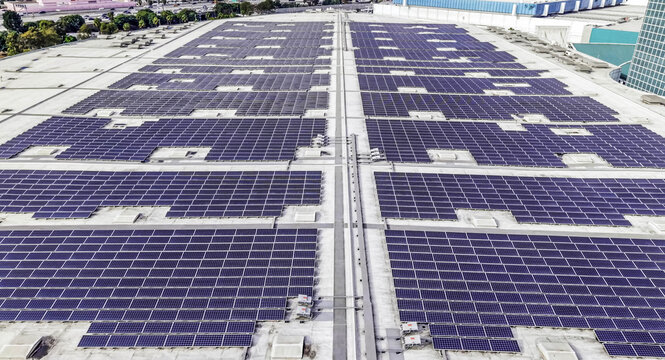 Aerial view of a large solar array covering the flat roof of a commercial building in Los Angeles, California, United States.