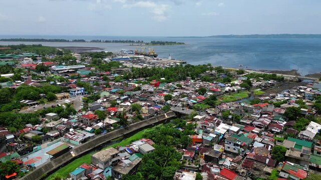 Aerial view from PNR Road toward Tabaco Port in Tabaco City, Albay, showing the urban landscape, roads, waterfront and port area, with Mayon Volcano visible in the background.
