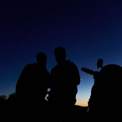 Amateur astronomers observing stars, planets, Moon and other celestial objects with a telescope in nature. © astrosystem