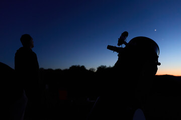 Amateur astronomer observing stars, planets, Moon and other celestial objects with a telescope in nature. © astrosystem