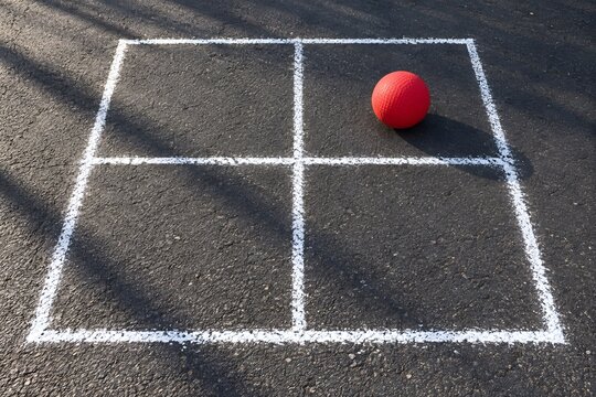 Four square playground grid with a red rubber ball