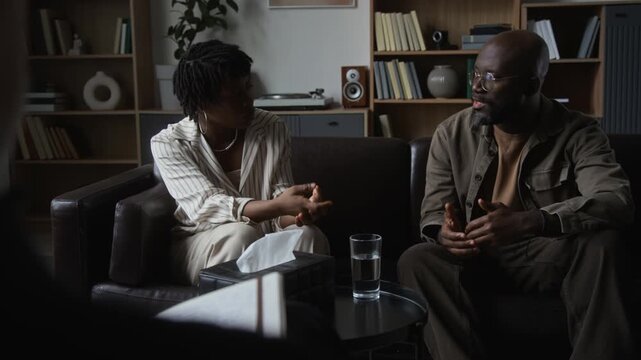 African American couple gesturing during relationship therapy session with counselor. Useful for mental health services, marriage counseling promos, and psychology projects